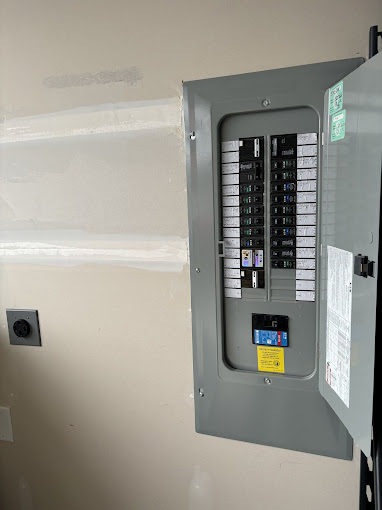 A gray electrical panel mounted to the side of a wall