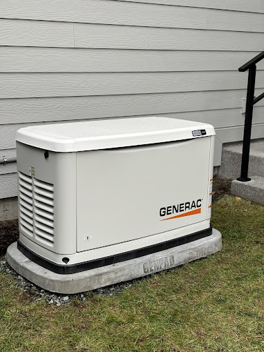 A generator sitting on the grass in front of a house