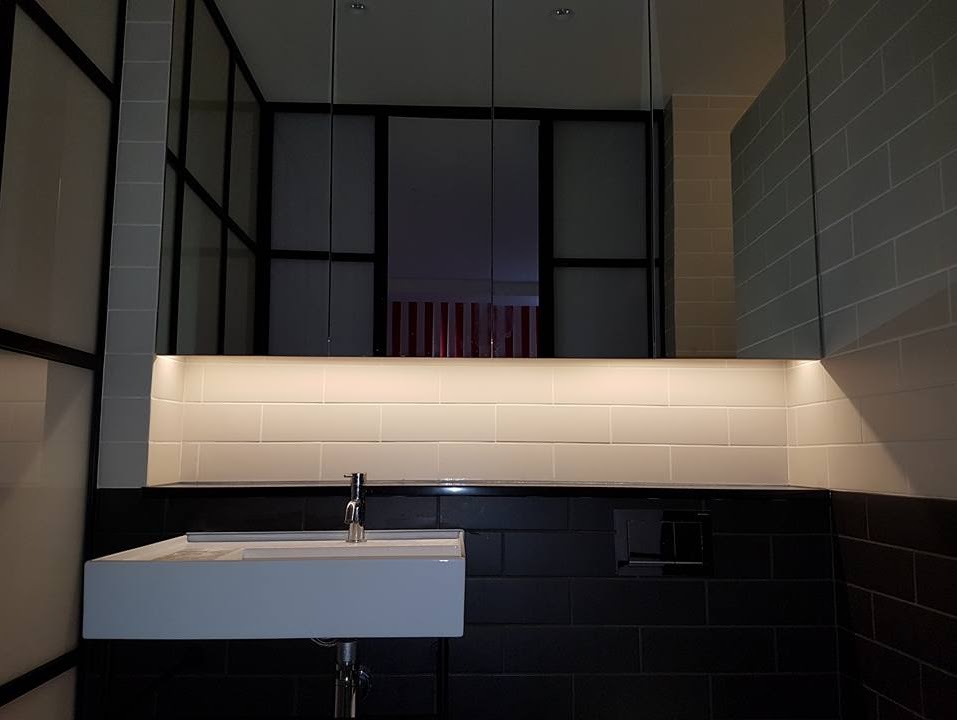 A white sink sitting under a mirror in a bathroom